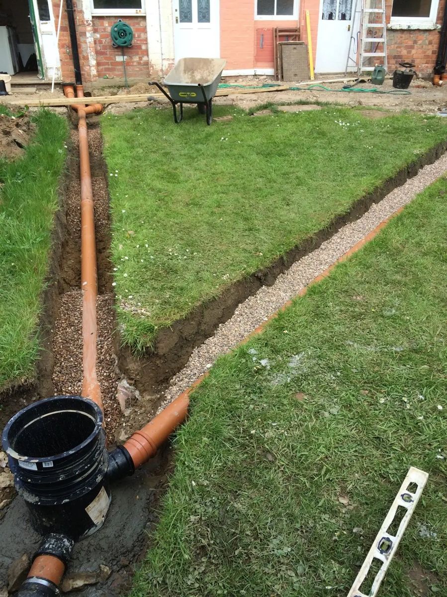 Drain run and chamber laid in a trench across a lawn